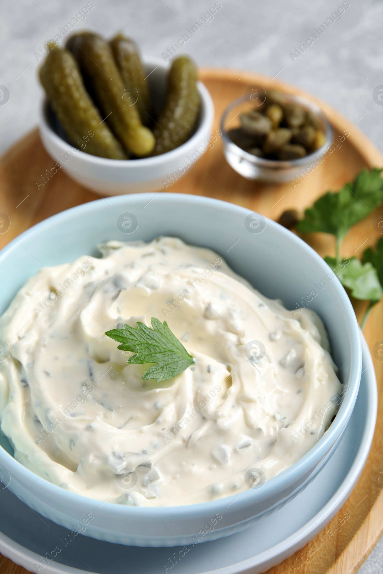 Photo of Tasty tartar sauce and ingredients on table, closeup