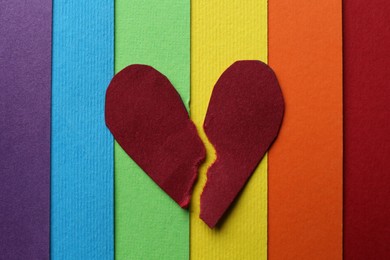 Halves of torn paper heart on colorful background, top view. Breakup concept