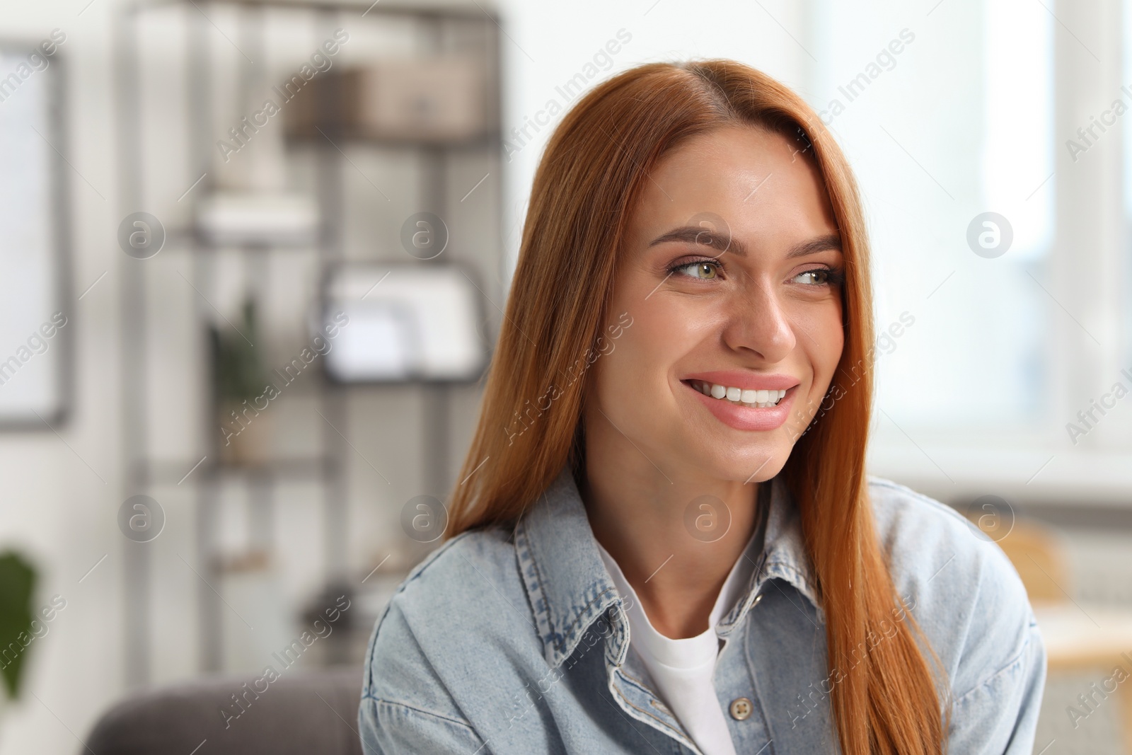 Photo of Portrait of beautiful smiling young woman. Happy lady with red hair at home. Space for text