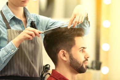 Image of Barber making stylish haircut with professional scissors in beauty salon