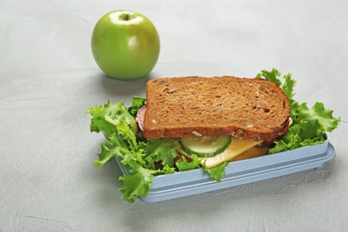 Photo of Lunch box with tasty sandwich on table