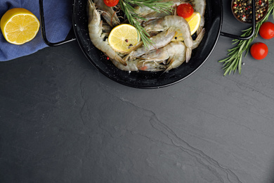 Photo of Flat lay composition with raw shrimps on black table. Space for text