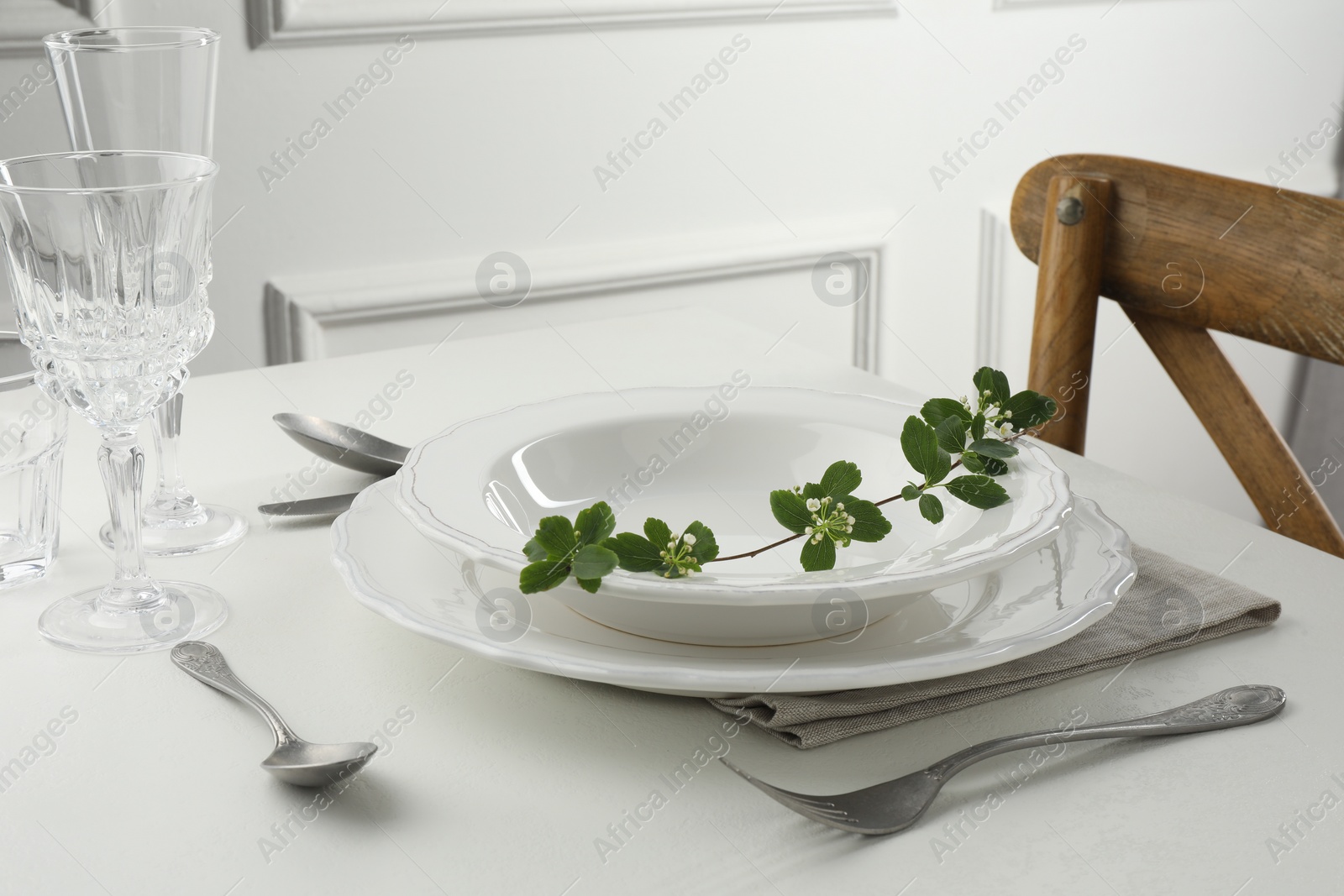 Photo of Stylish setting with cutlery and plates on white textured table