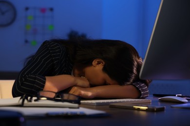 Tired overworked businesswoman napping at night in office
