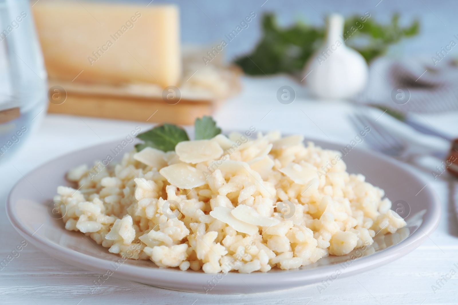 Photo of Delicious risotto with cheese on white wooden table, closeup