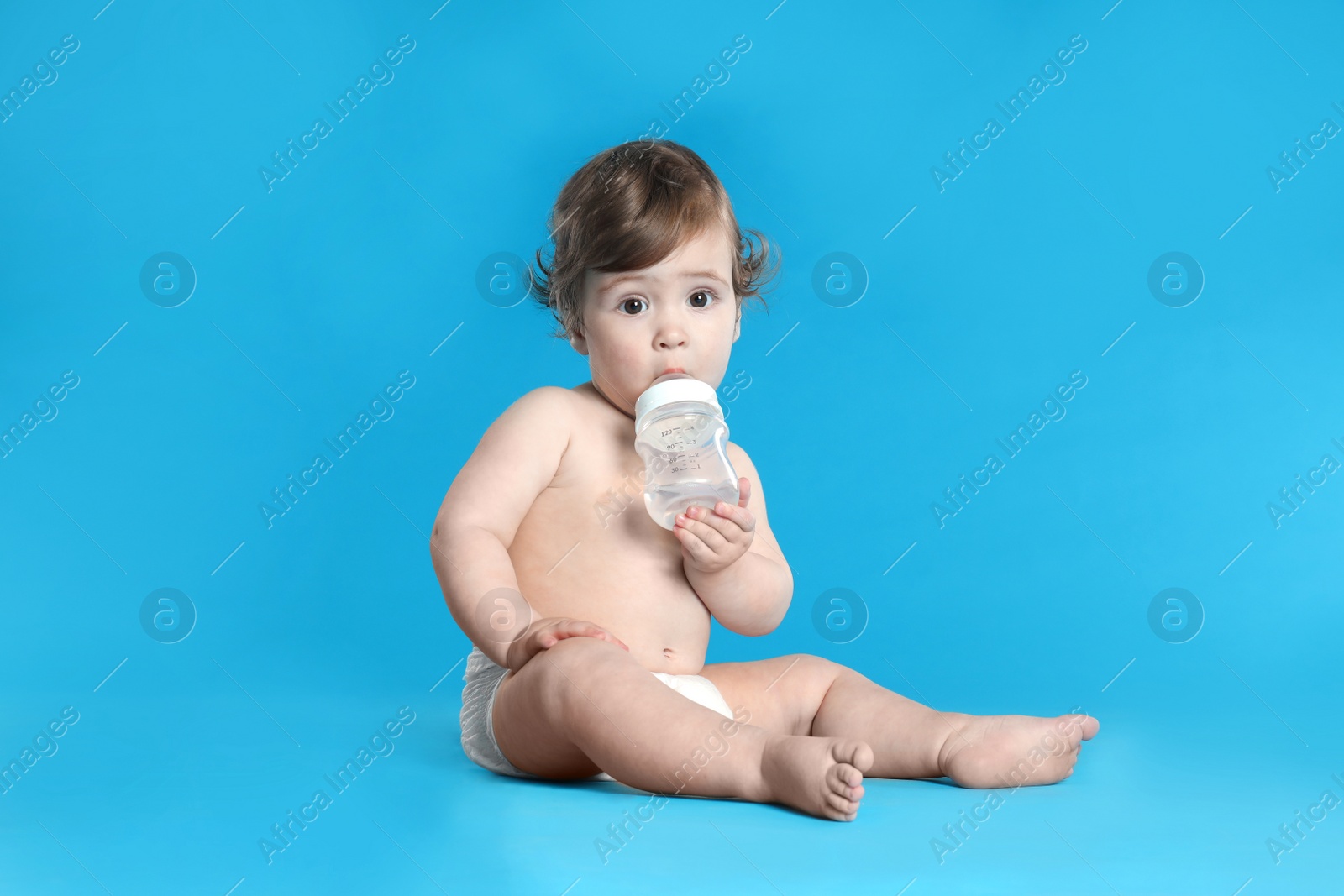 Photo of Cute little baby in diaper on light blue background