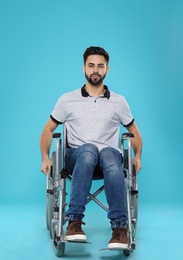 Photo of Young man in wheelchair on color background