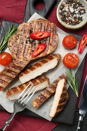 Photo of Grilled pork steaks with rosemary, spices, vegetables and cutlery on table, top view