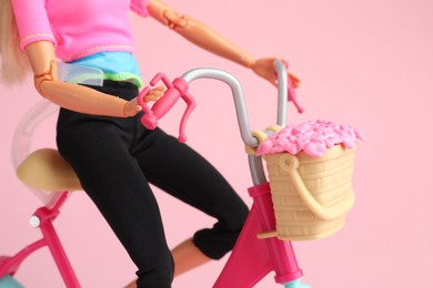 Photo of Mykolaiv, Ukraine - September 2, 2023: Barbie doll with bicycle on pink background, closeup
