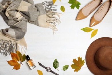 Photo of Stylish outfit and autumn leaves on white wooden background, flat lay with space for text. Trendy warm clothes