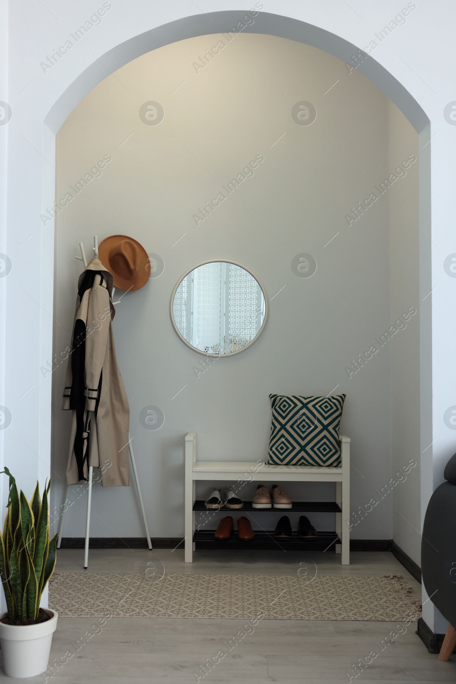 Photo of Hallway interior with clothes rack and round mirror