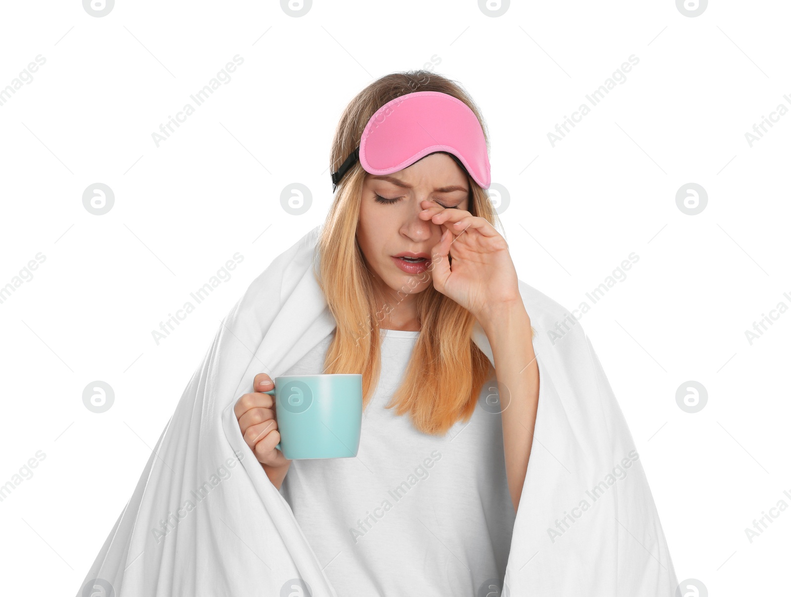 Photo of Woman in sleeping mask wrapped with blanket holding cup on white background