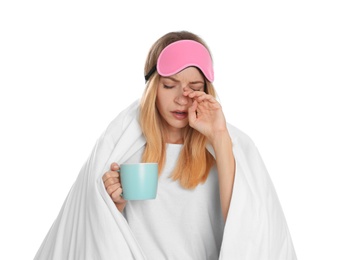 Photo of Woman in sleeping mask wrapped with blanket holding cup on white background