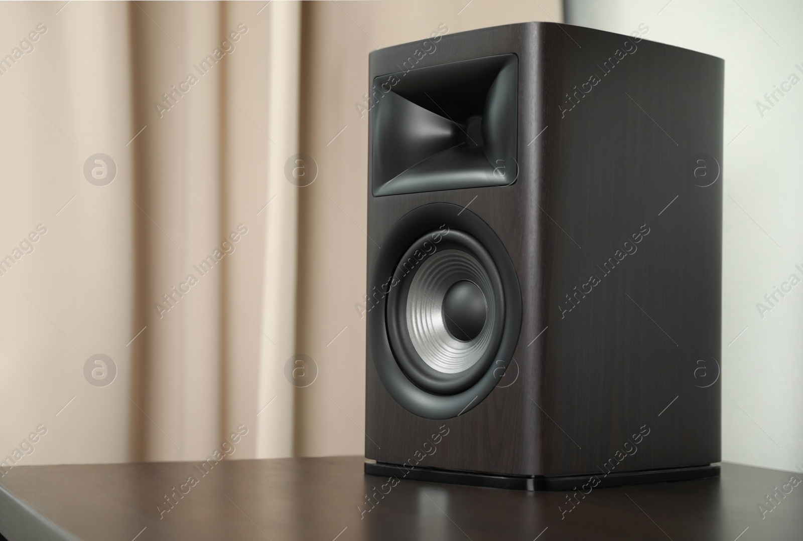 Photo of One sound speaker on table indoors. Space for text