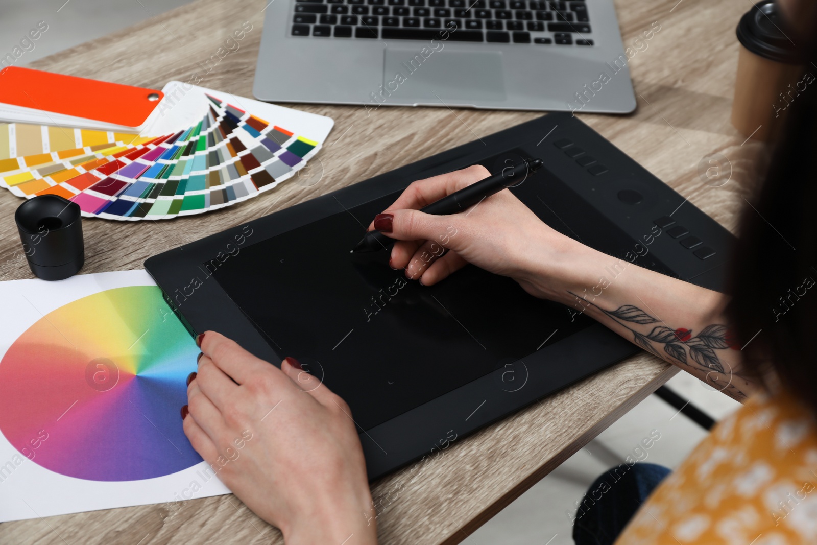 Photo of Professional designer with graphic tablet at wooden table, closeup