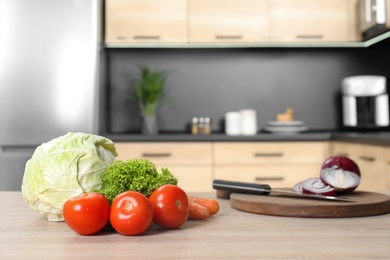 Photo of Fresh vegetables on wooden table in kitchen. Space for text