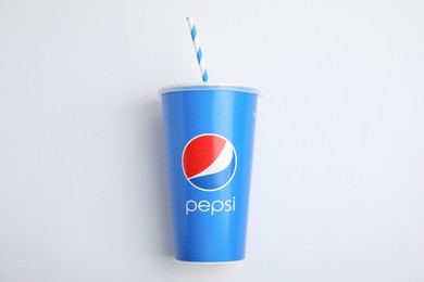 Photo of MYKOLAIV, UKRAINE - JUNE 9, 2021: Paper Pepsi cup with straw on white background, top view