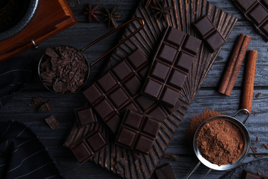 Photo of Flat lay composition with dark chocolate on black wooden table