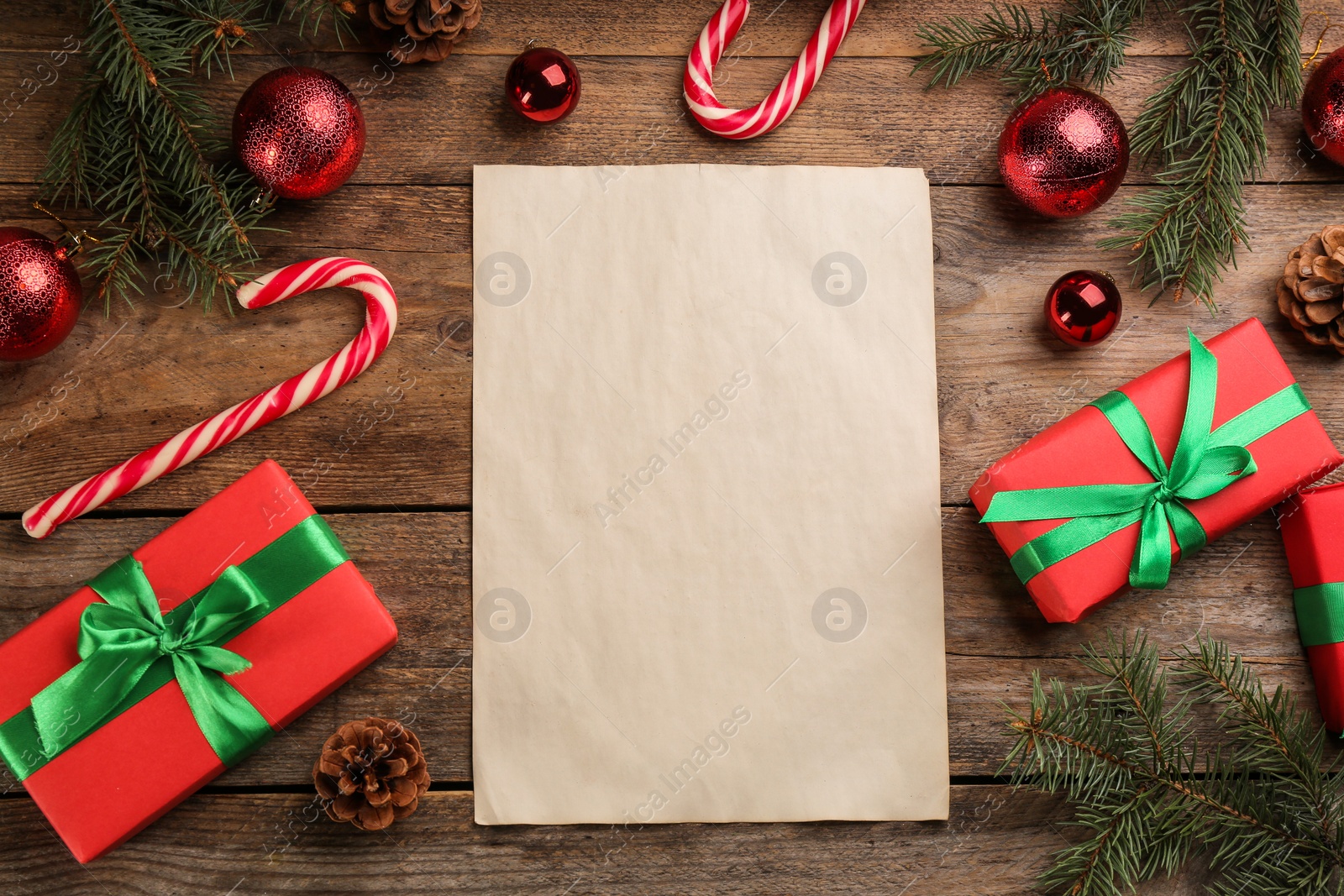 Photo of Flat lay composition with paper and Christmas decor on wooden table. Writing letter to Santa Claus