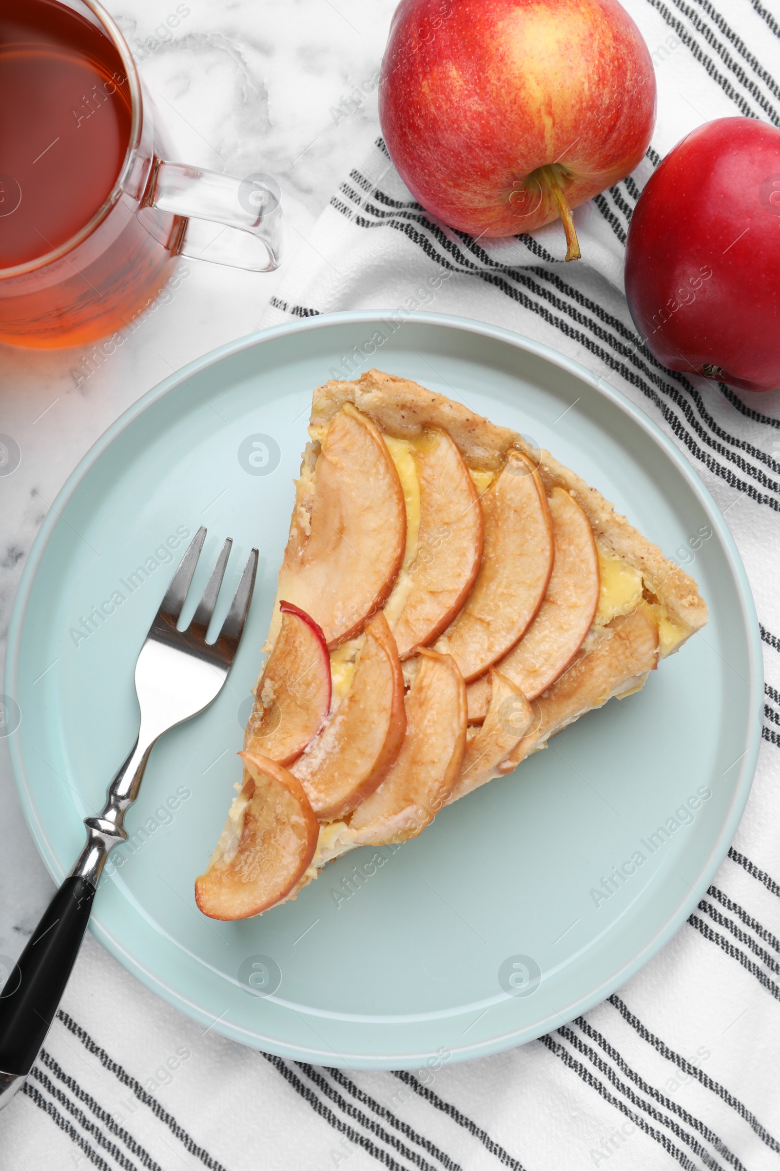 Photo of Freshly baked delicious apple pie served on white marble table, flat lay