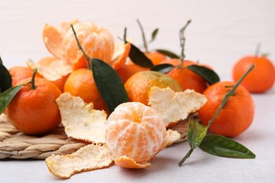 Photo of Many fresh ripe tangerines and leaves on white table