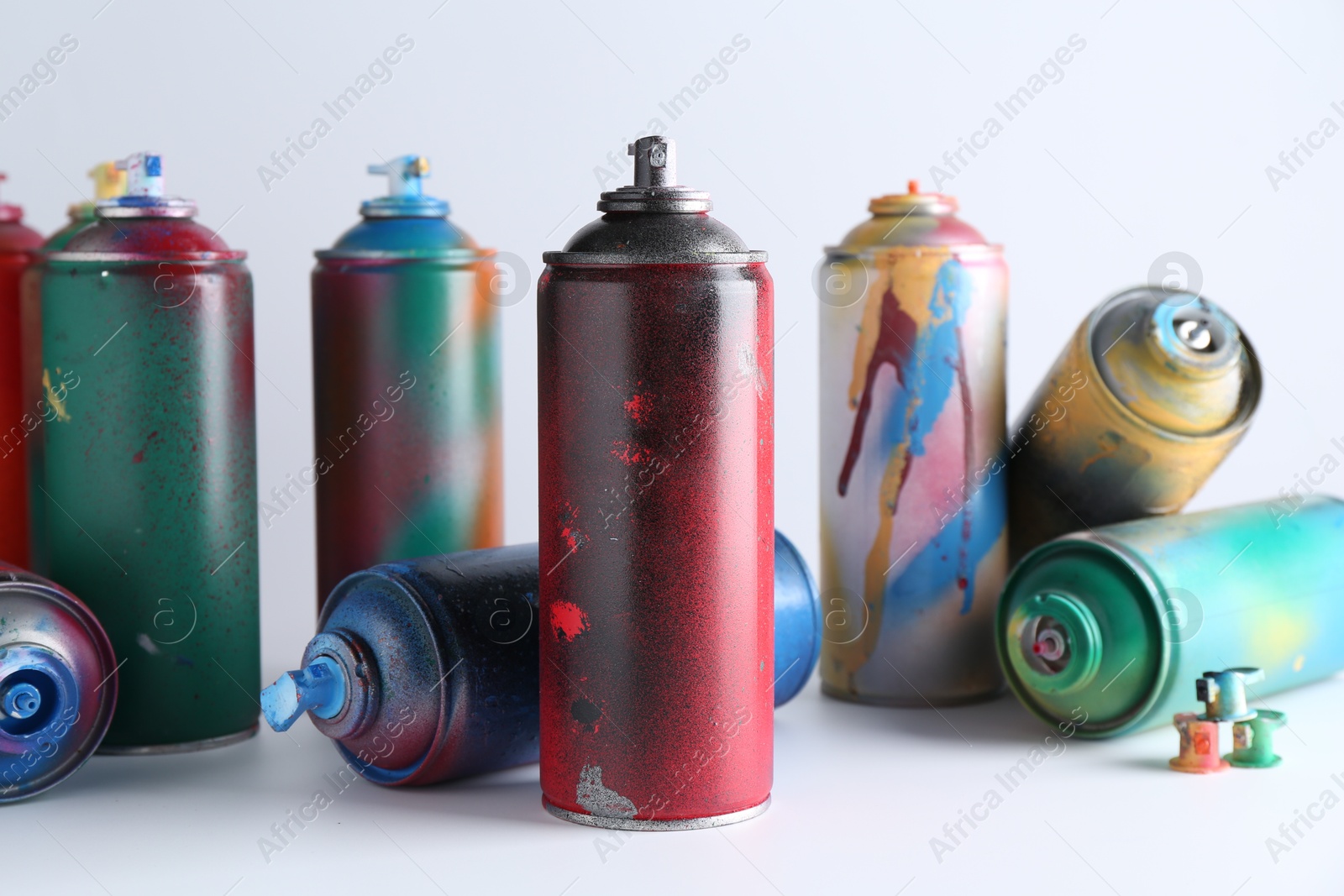 Photo of Many spray paint cans on white background