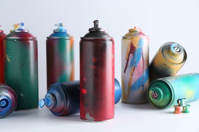 Many spray paint cans on white background