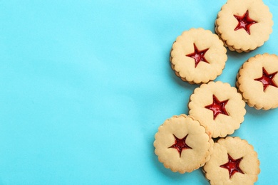 Photo of Traditional Christmas Linzer cookies with sweet jam on color background, top view