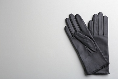 Pair of stylish leather gloves on light grey background, flat lay. Space for text