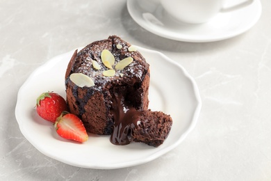 Plate of delicious fresh fondant with hot chocolate and strawberries on table. Lava cake recipe