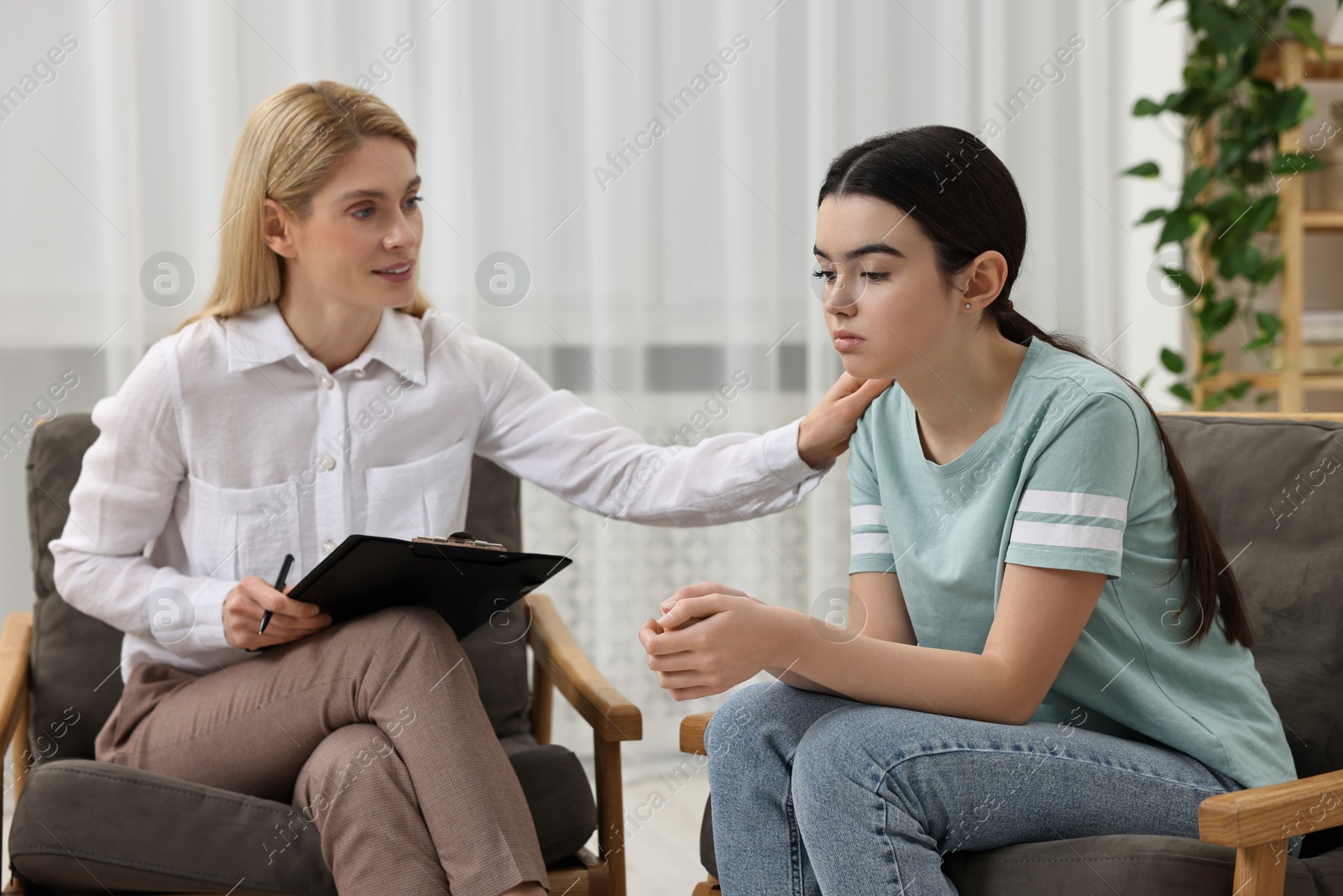 Photo of Psychologist working with teenage girl in office