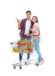 Photo of Young couple with full shopping cart on white background