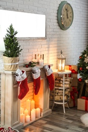 Photo of Stylish interior with beautiful Christmas tree and decorative fireplace