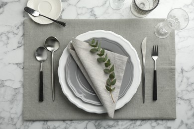 Photo of Stylish setting with cutlery, glasses and plates on white marble table, flat lay