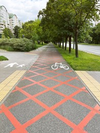 Bicycle lane with signs painted on asphalt in city