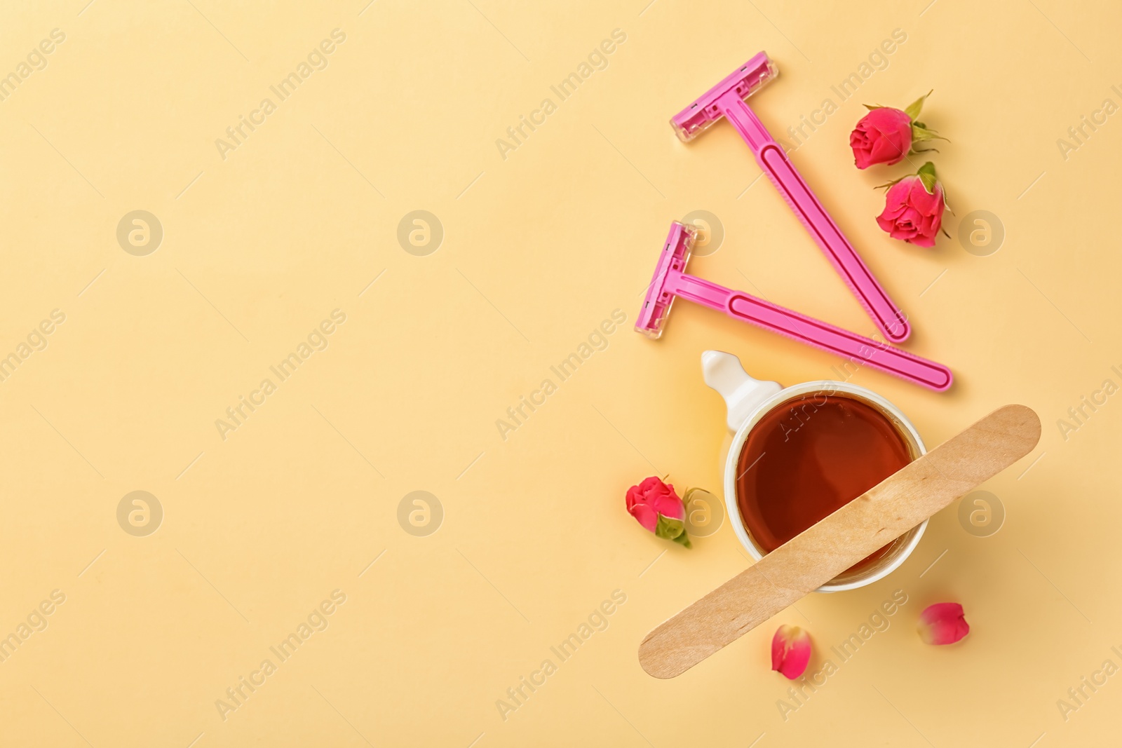 Photo of Sugaring paste and razors on color background, flat lay