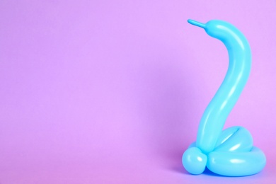 Photo of Snake figure made of modelling balloon on color background. Space for text