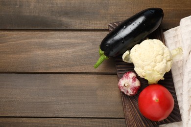 Photo of Many different vegetables on wooden table, top view. Space for text