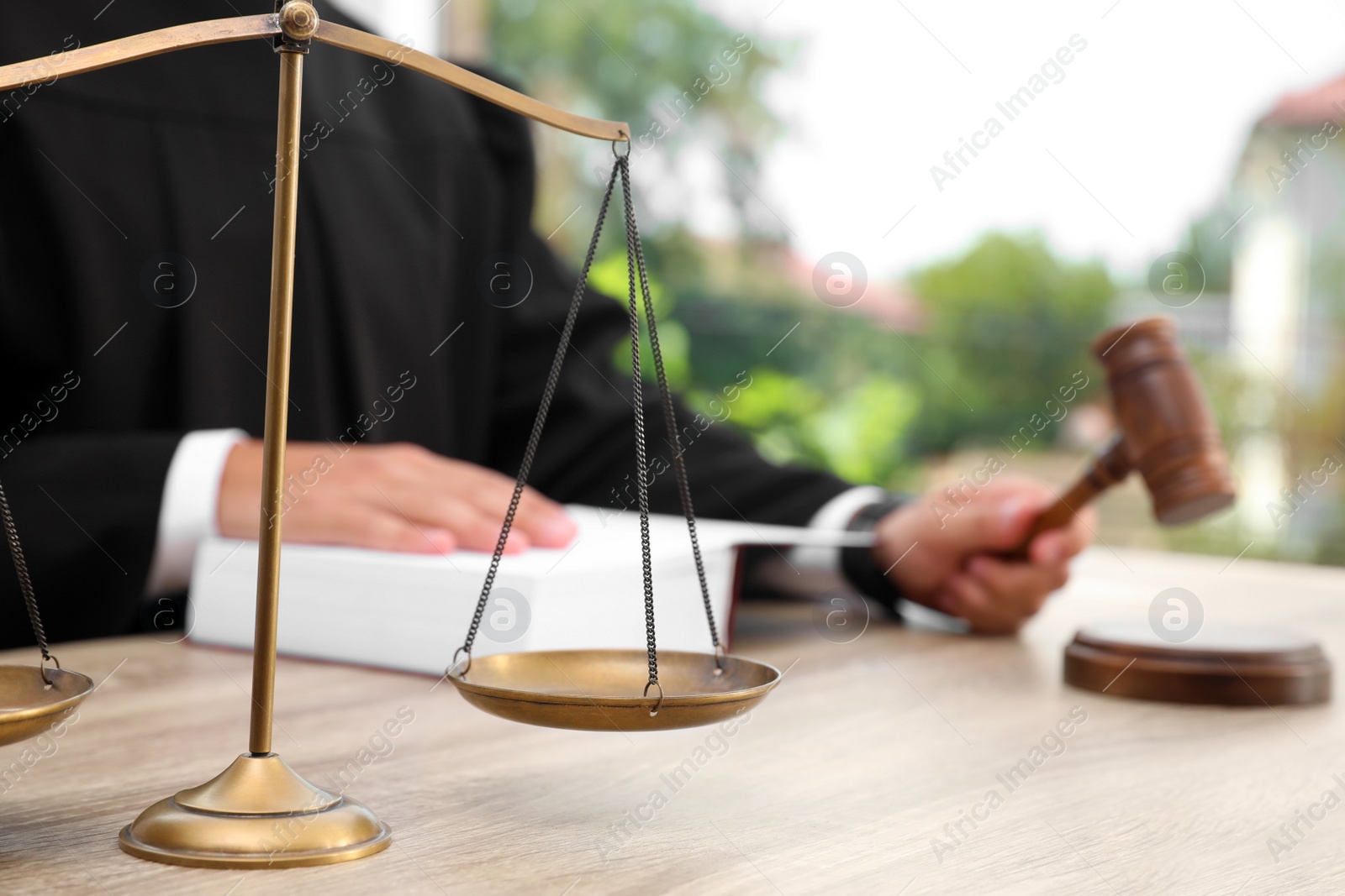 Photo of Scales of justice and blurred judge on background. Criminal law