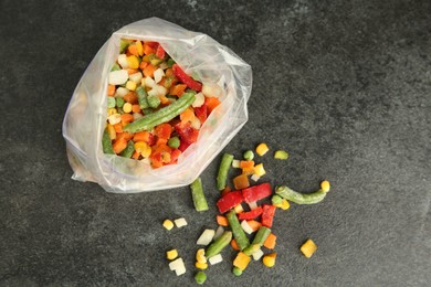 Photo of Zip bag with different frozen vegetables on grey table, top view. Space for text