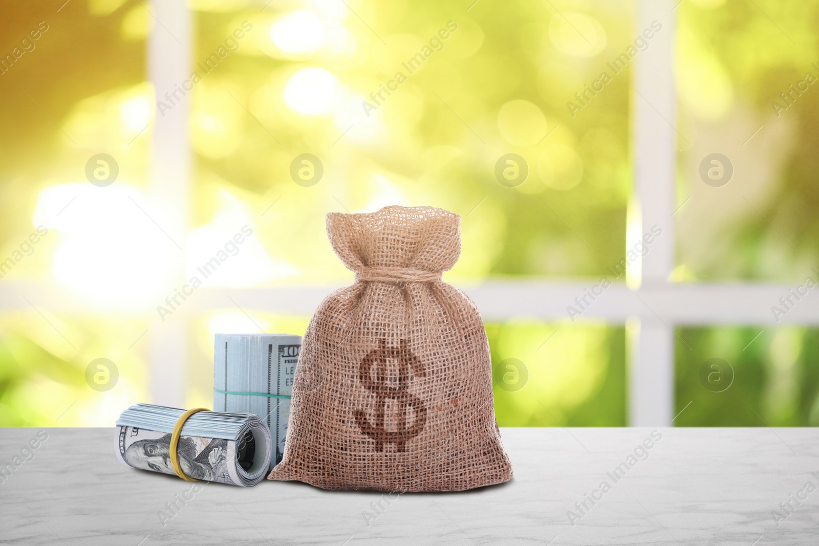 Image of Burlap bag with dollar sign and banknotes on white table indoors