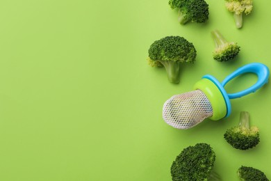 Photo of Nibbler with boiled broccoli on green background, flat lay. Space for text