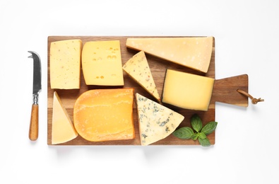 Photo of Wooden board with different kinds of cheese, basil and knife on white background, top view