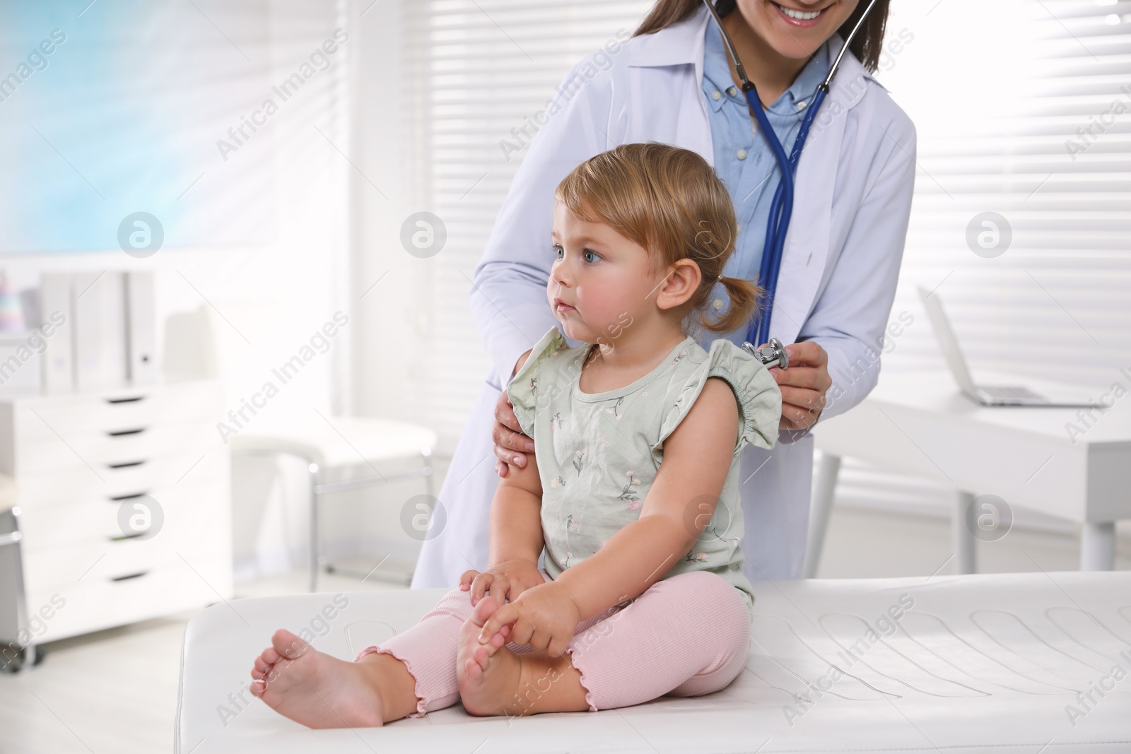 Photo of Pediatrician examining baby with stethoscope in clinic