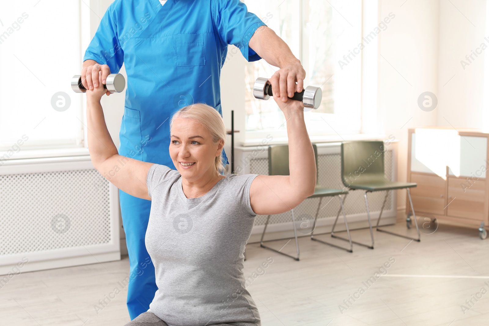 Photo of Physiotherapist working with patient in clinic. Rehabilitation therapy