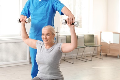 Photo of Physiotherapist working with patient in clinic. Rehabilitation therapy