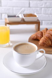 Photo of Fresh croissants and coffee on white table. Tasty breakfast