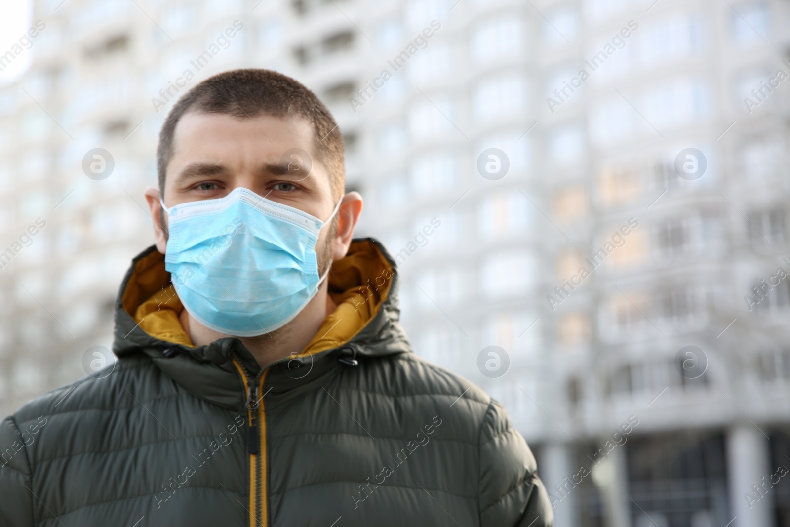 Photo of Man wearing disposable mask outdoors. Dangerous virus