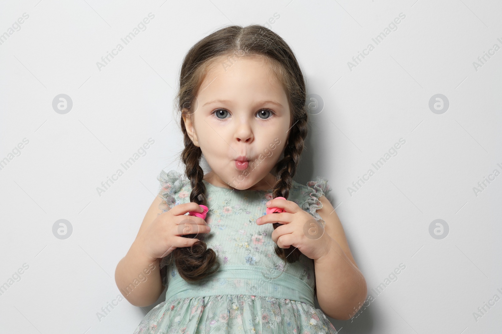 Photo of Cute little girl on light grey background