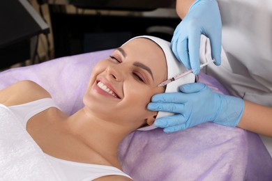 Young woman getting facial injection in beauty salon. Cosmetic procedure